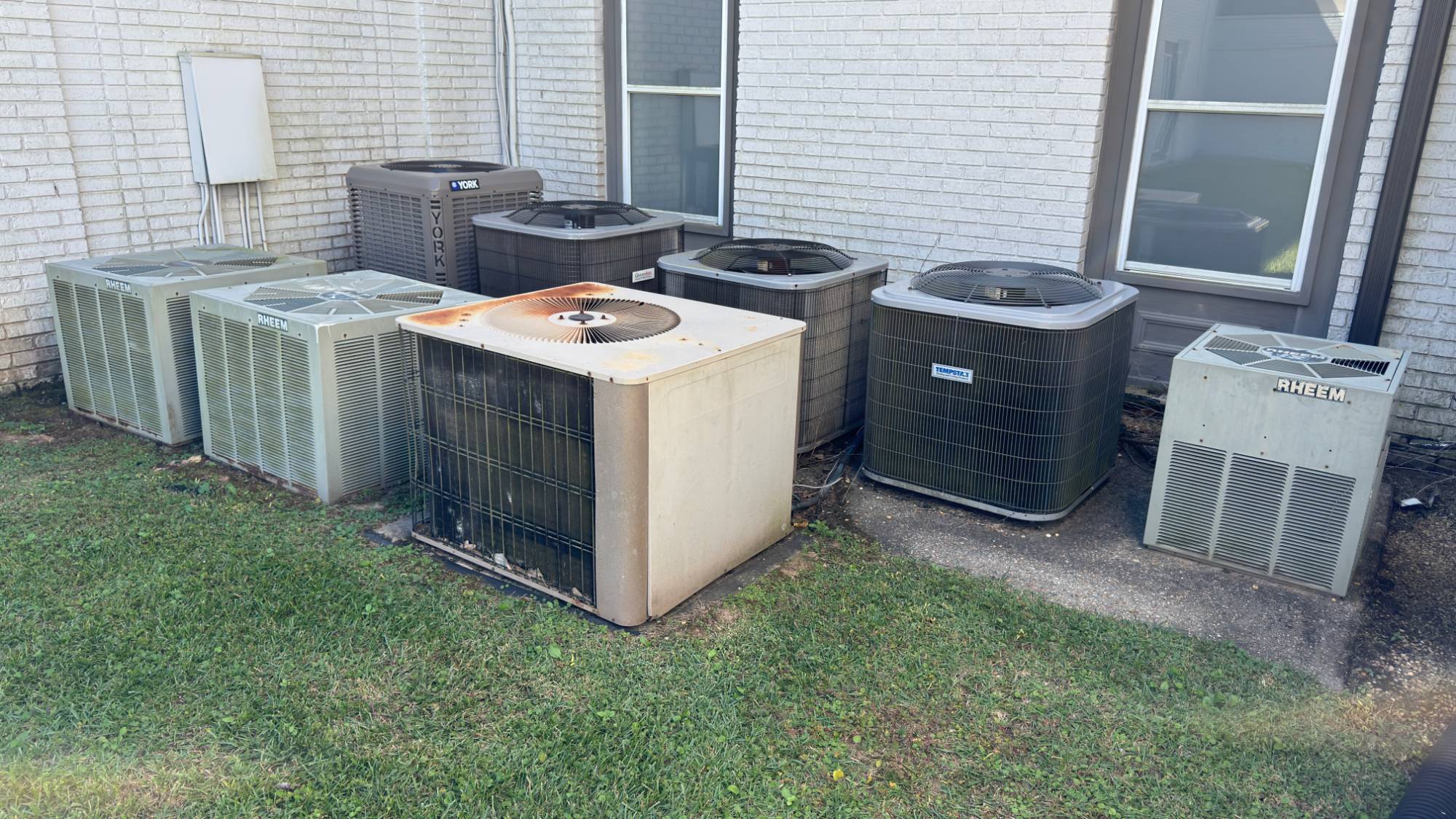 Seven outdoor air conditioning units beside the building