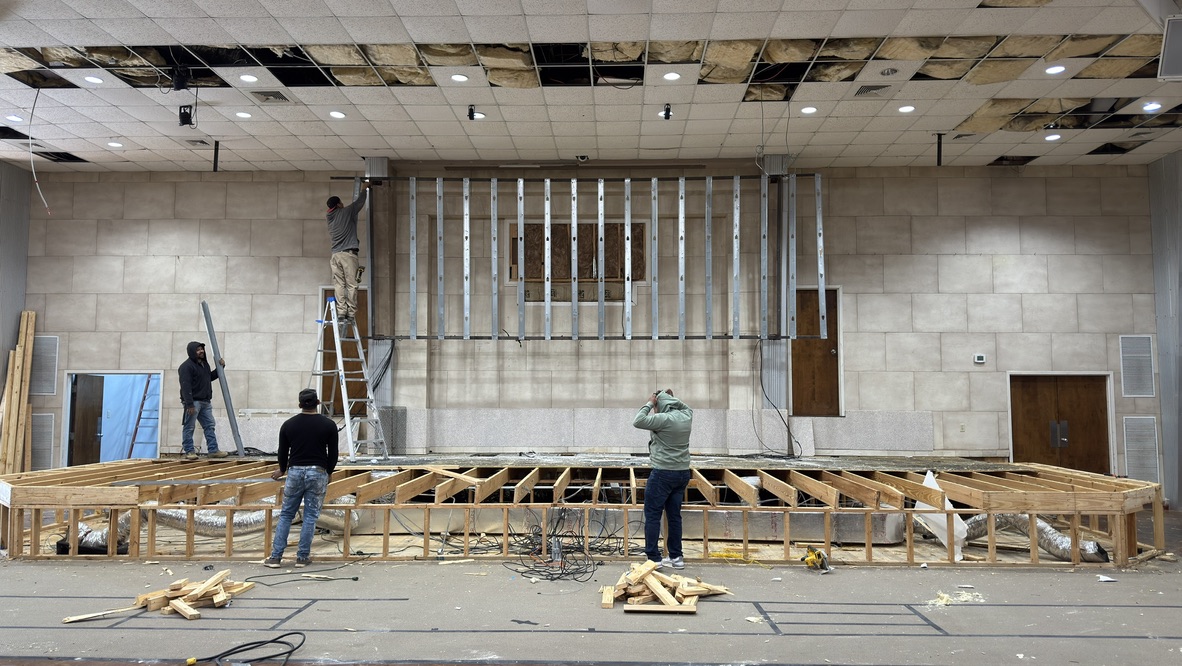 Crew framing the new stage in front of the old stage wall