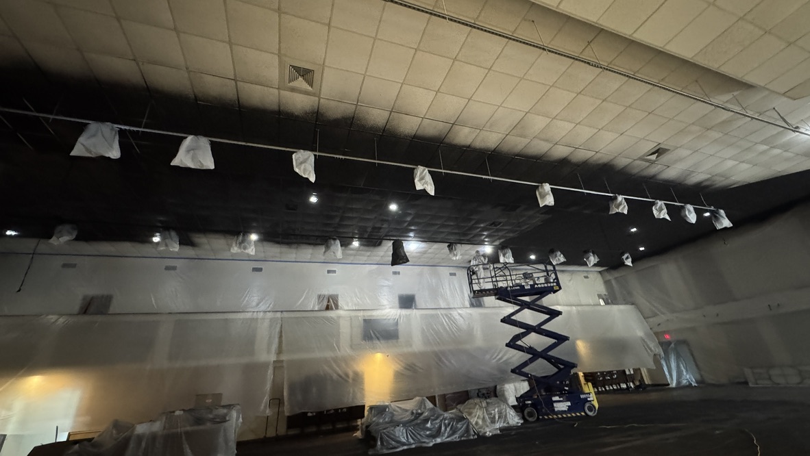 Painting the auditorium ceiling black from a scissor lift