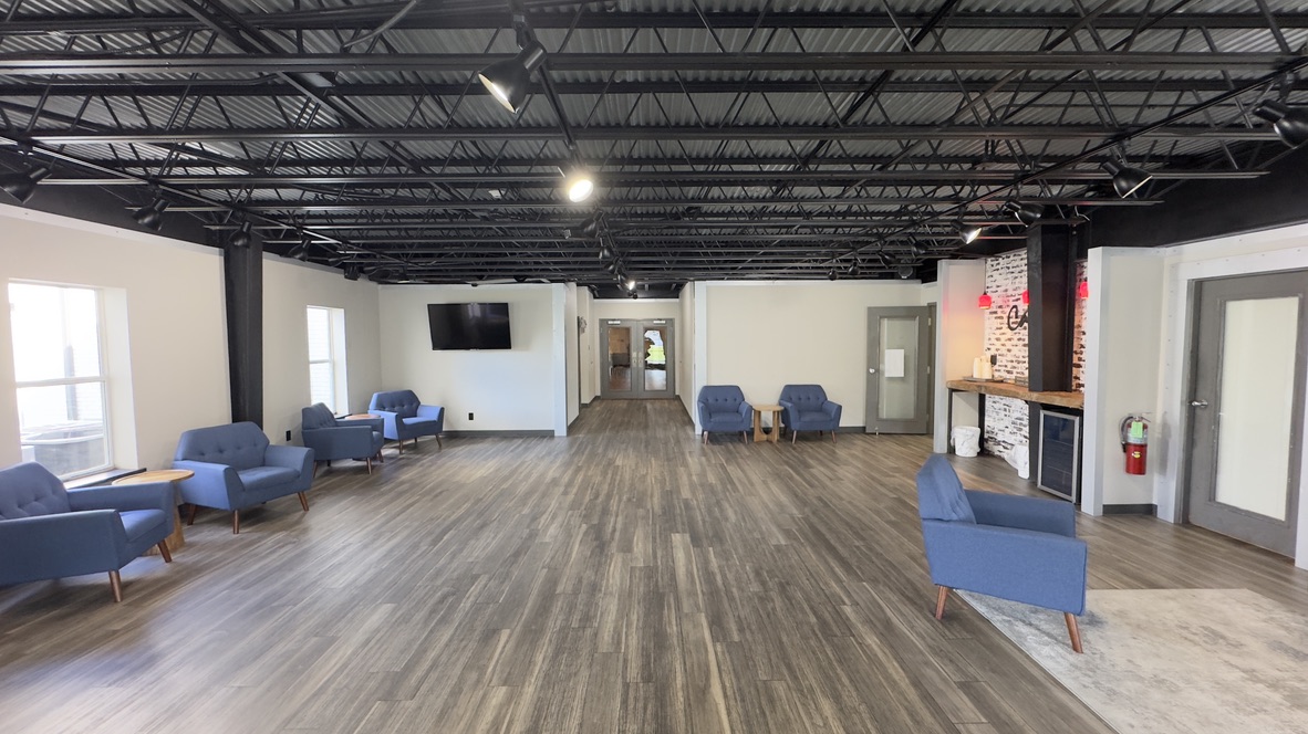 The current foyer with blue chairs and an open ceiling