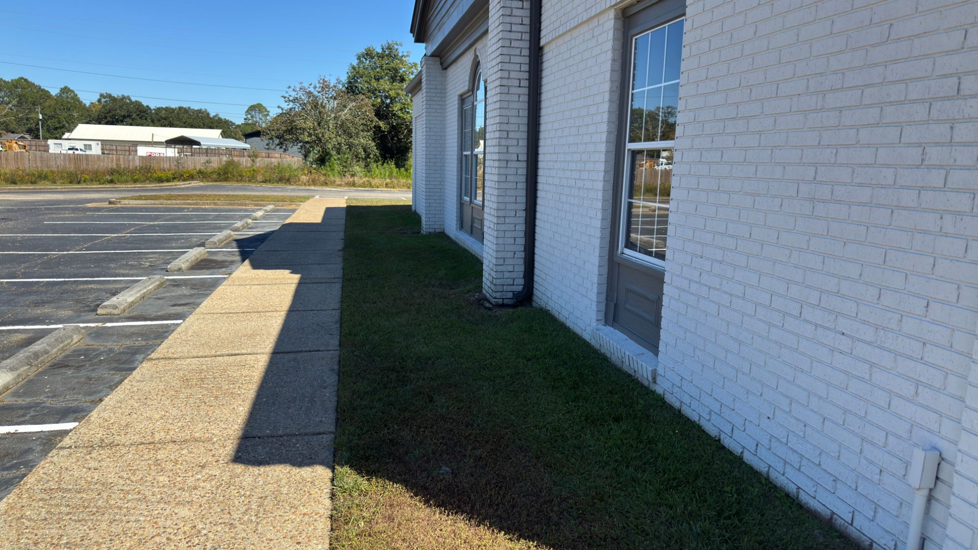 Bare grass strip along the side of the building