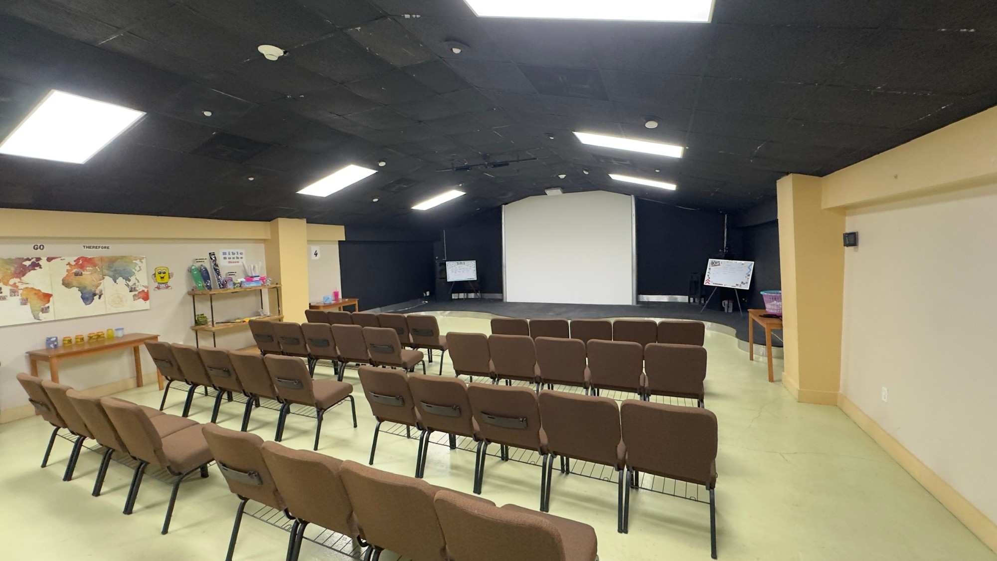 A kids room before the renovation, with brown chairs and a projector screen
