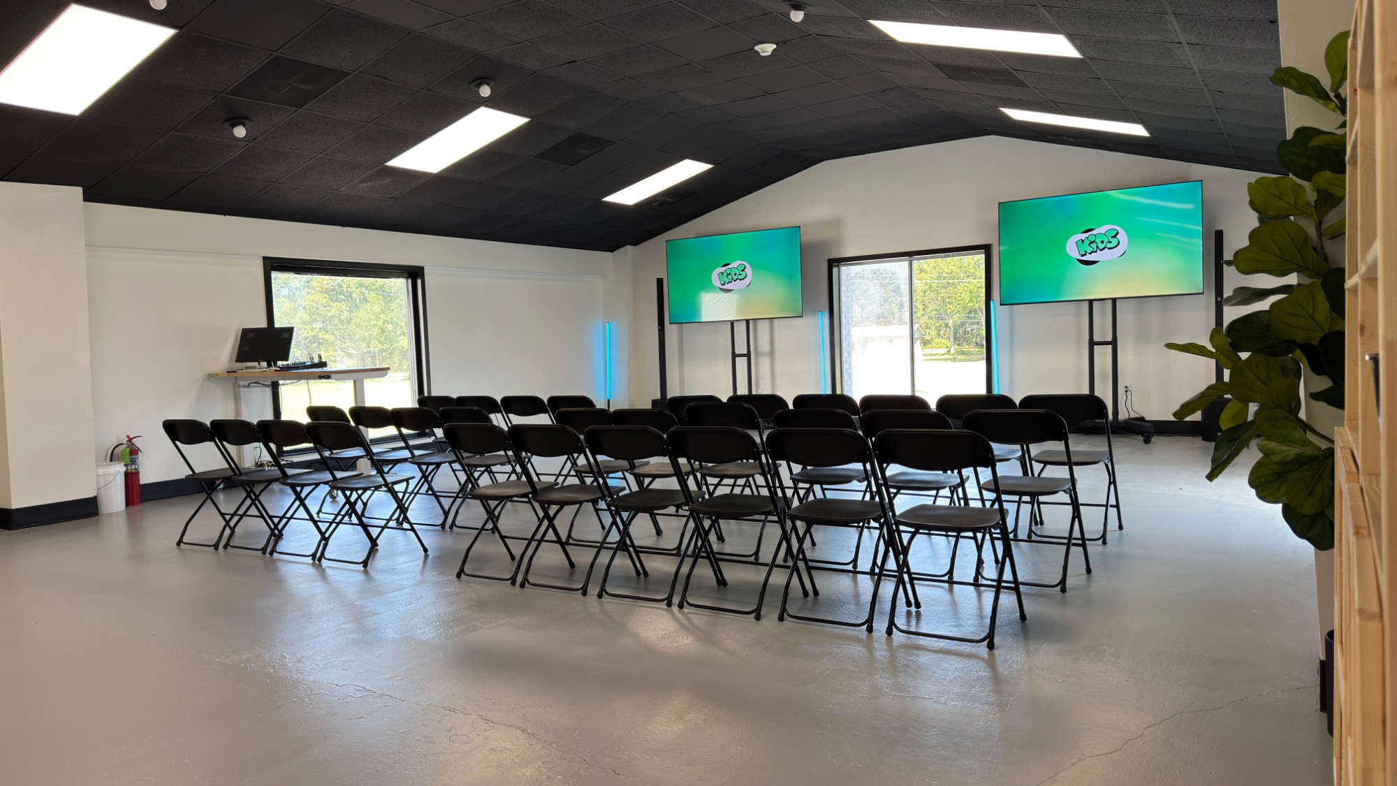 The renovated Loft with rows of chairs and two screens