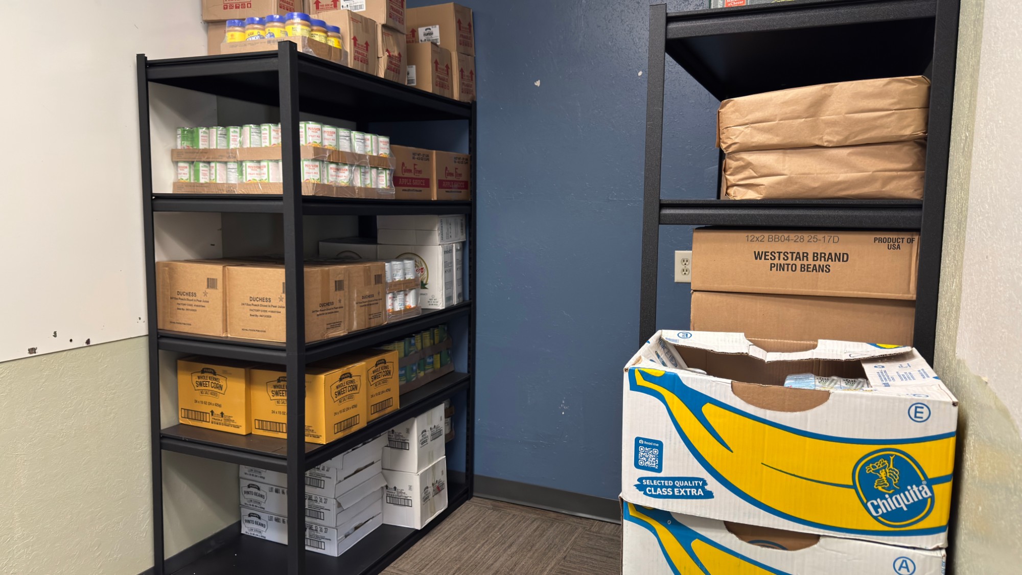 Shelves stocked with canned food and boxes for Neighbor Boxes