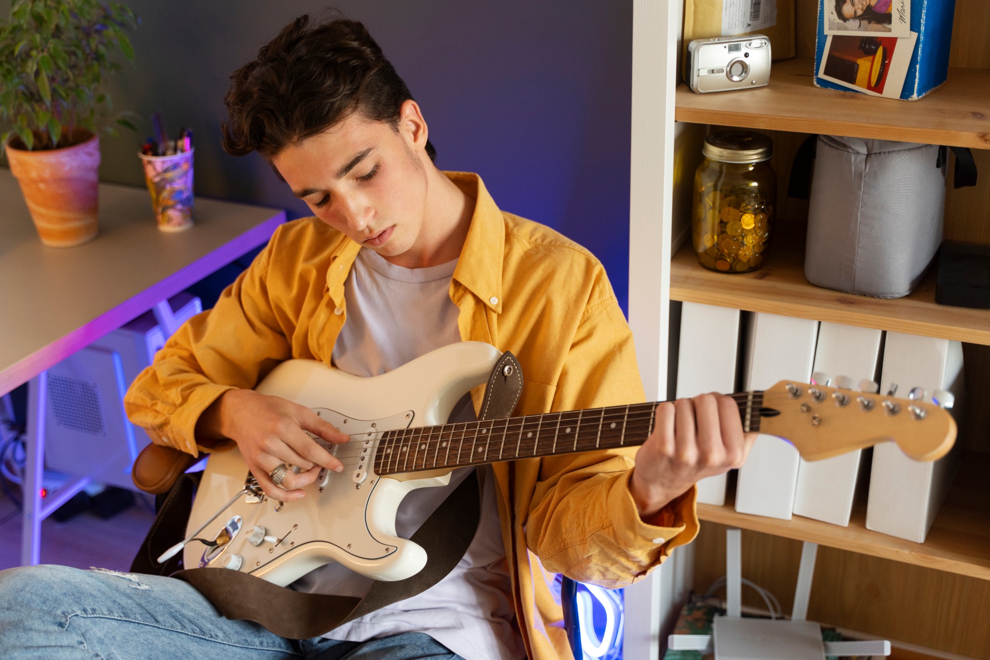 A teenager learning to play electric guitar